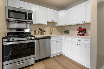 A kitchen with white cabinets and stainless steel appliances